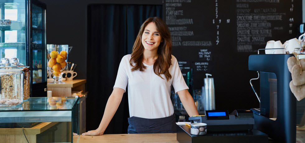 a young woman behind the counter of a café shop