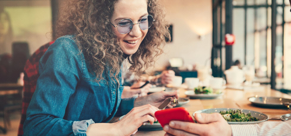 Woman looking smartphone in restaurant