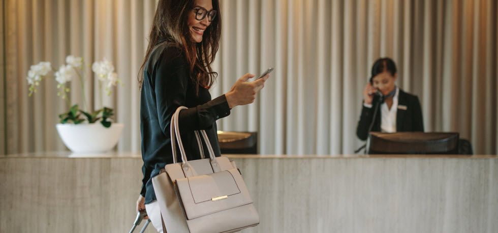 Woman using mobile phone in a hotel lobby