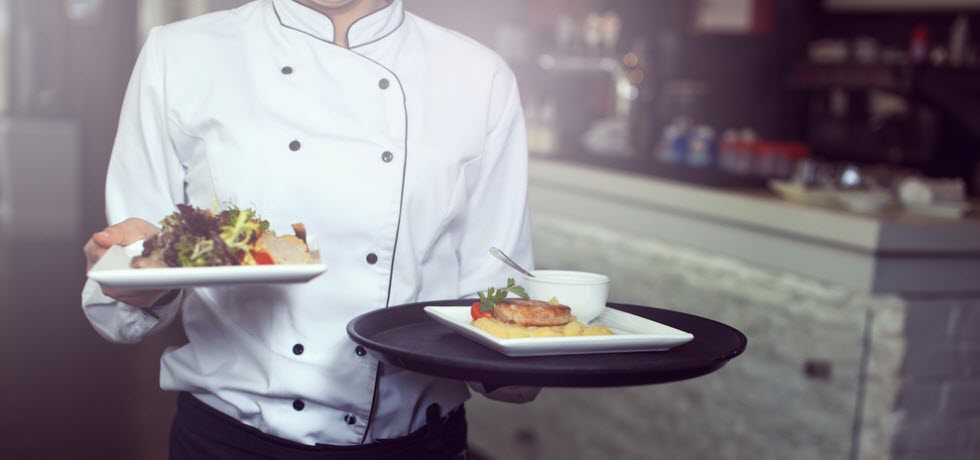 Chief cook holding plates with food