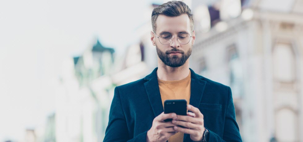 Handsome man using mobile for SMS chat