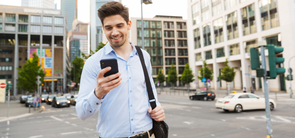 A young man reading an appointment reminder from mobile phone