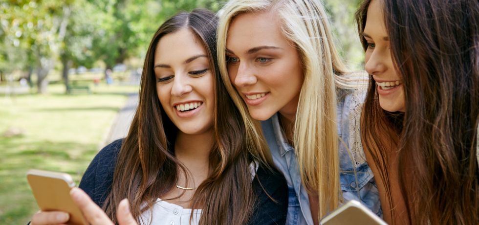 young girls watching a text message art on a mobile phone