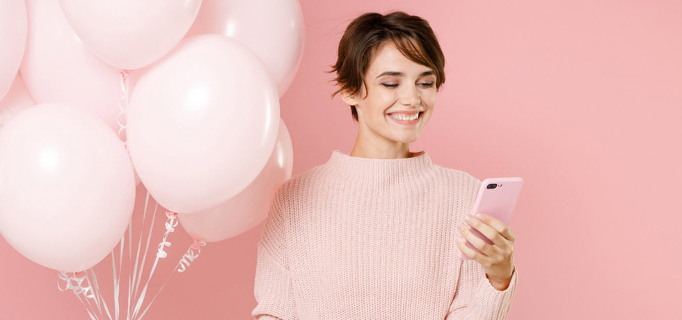 a young woman reads a birthday text message