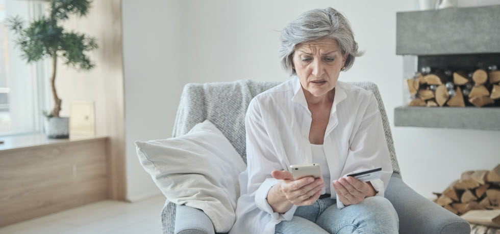 An elder lady got a suspecious phone call and looks a credit card in her hand